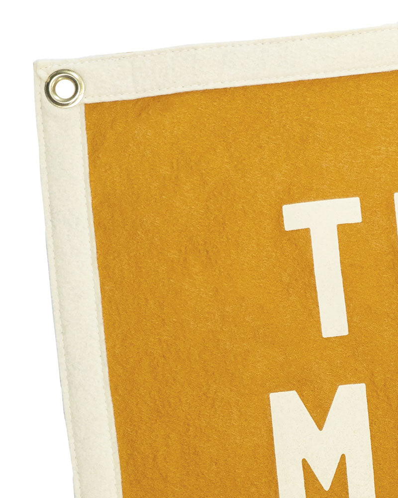 Orange felt flag banner corner with white letter T and metal grommet