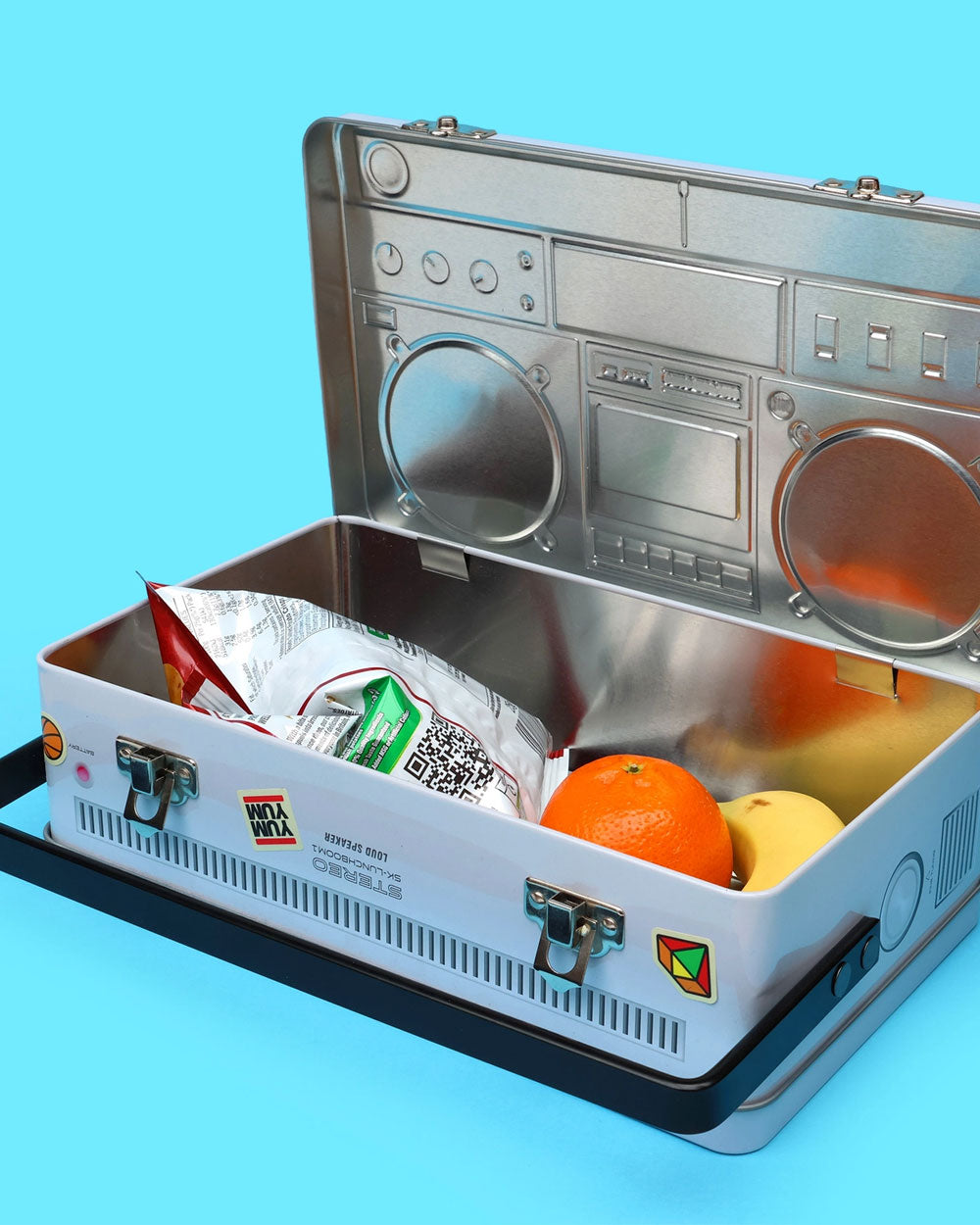 Open boombox lunch box with snack contents and orange and yellow items inside
