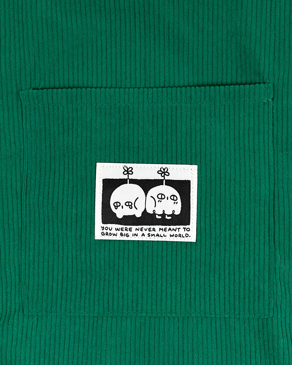 Green corduroy tote bag with character patch and top panel label
