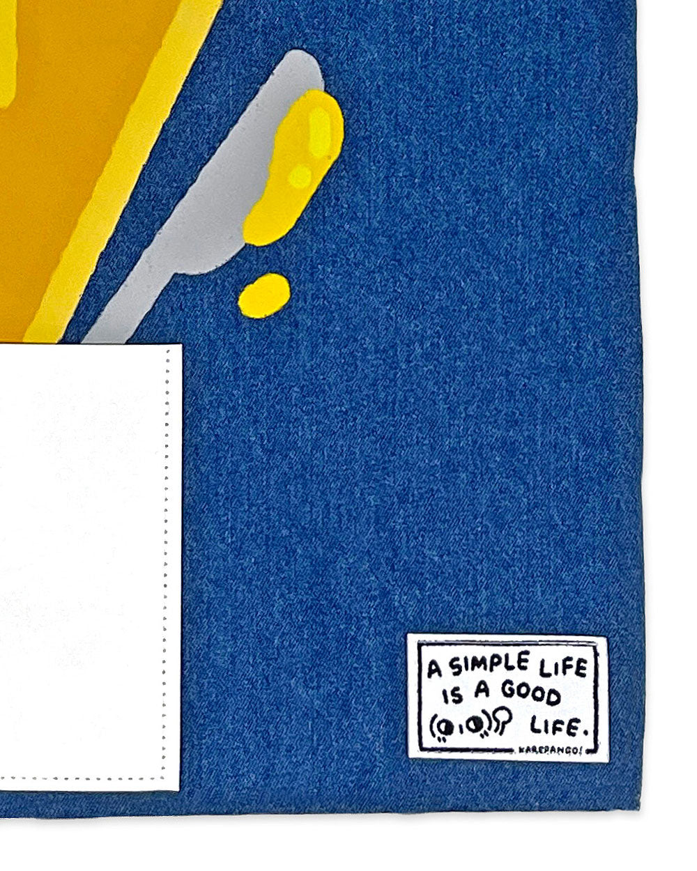 Close-up of blue denim tote bag with front pocket and printed text label
