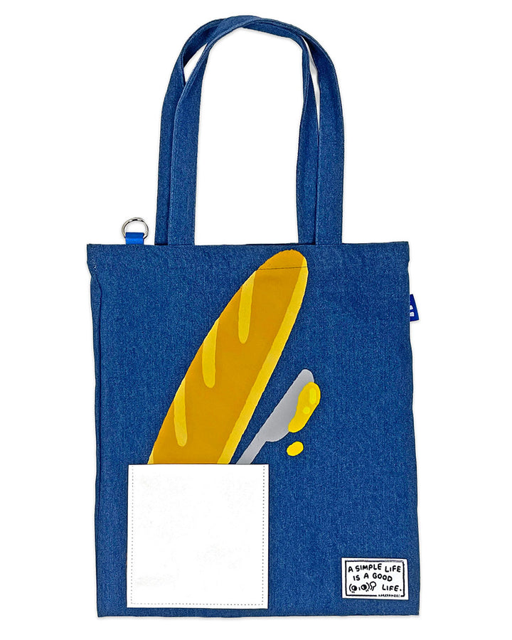 Blue denim tote bag with front pocket and yellow graphic patch with white insert