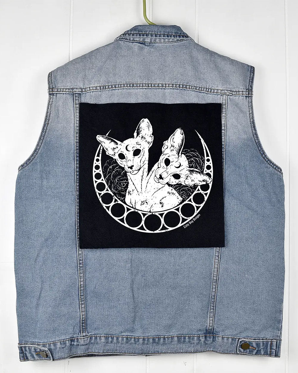 Black cat-illustration back patch displayed on the back of a denim vest