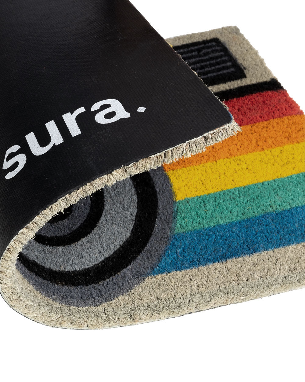 Corner of camera doormat with rainbow stripes, black border, and round lens icon