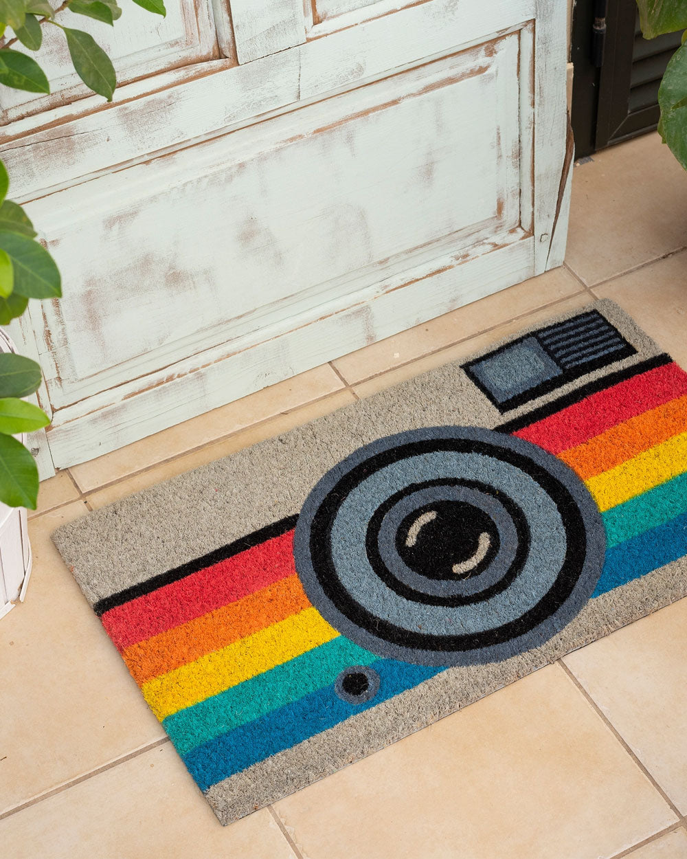 Camera-themed doormat with rainbow stripes and circular lens graphic
