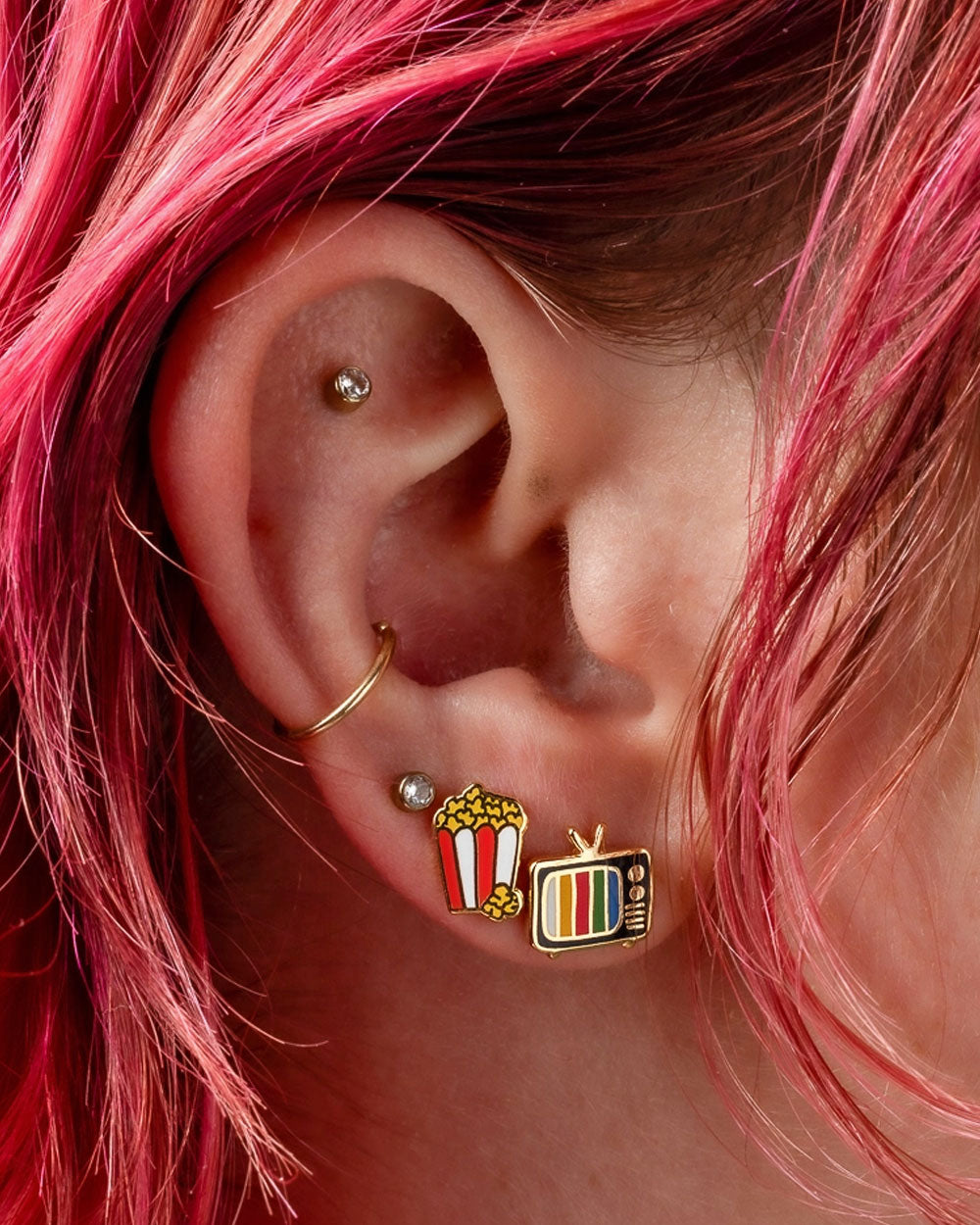 Popcorn and retro TV charm earrings with small gold hoop, worn on ear