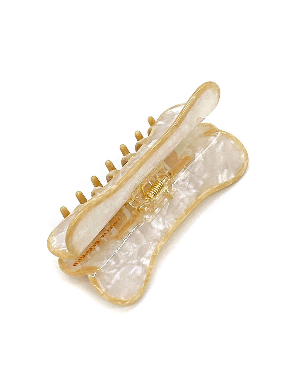 Translucent cream hair claw clip with gold-tone teeth and visible spring hinge