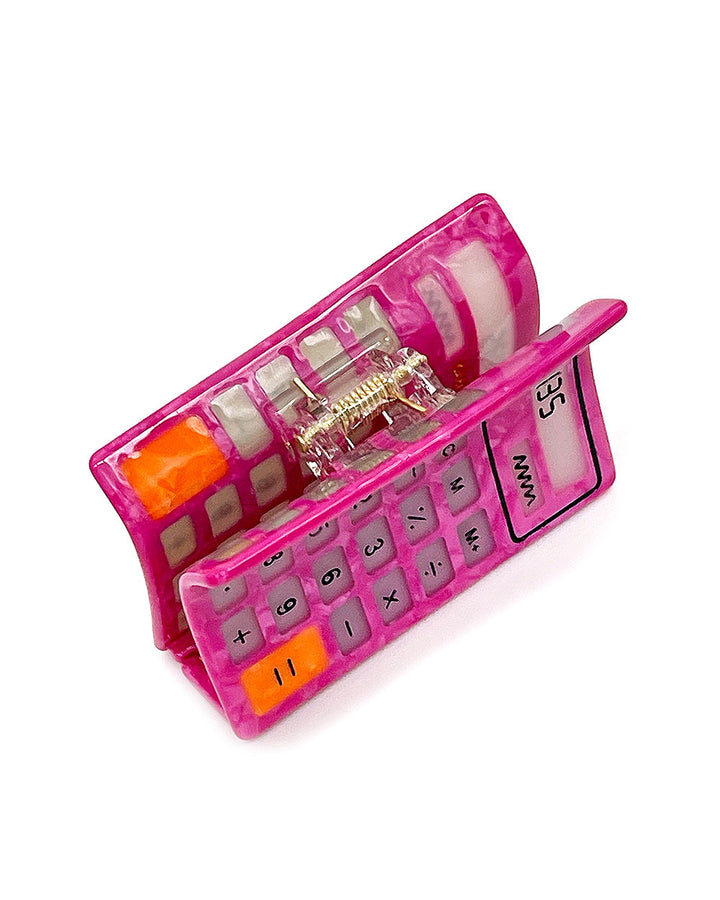 Pink calculator-style hair claw clip with open teeth and orange key accents
