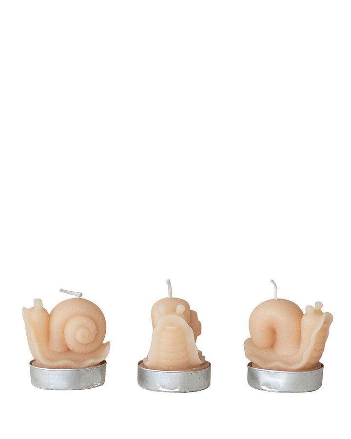 Three unlit snail tea lights in metal cups with curled shell details
