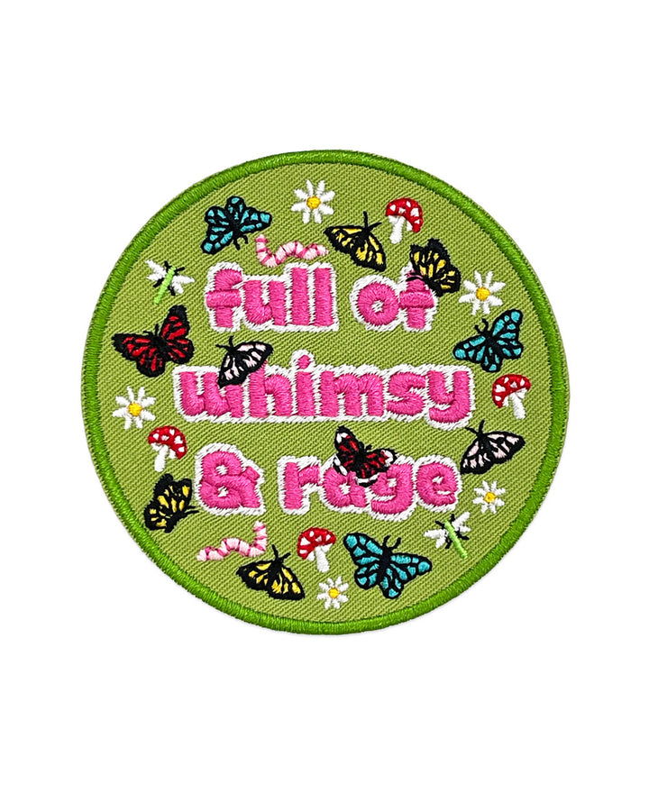Round green embroidered patch with pink 'Whimsy & Rage' text and insect motifs