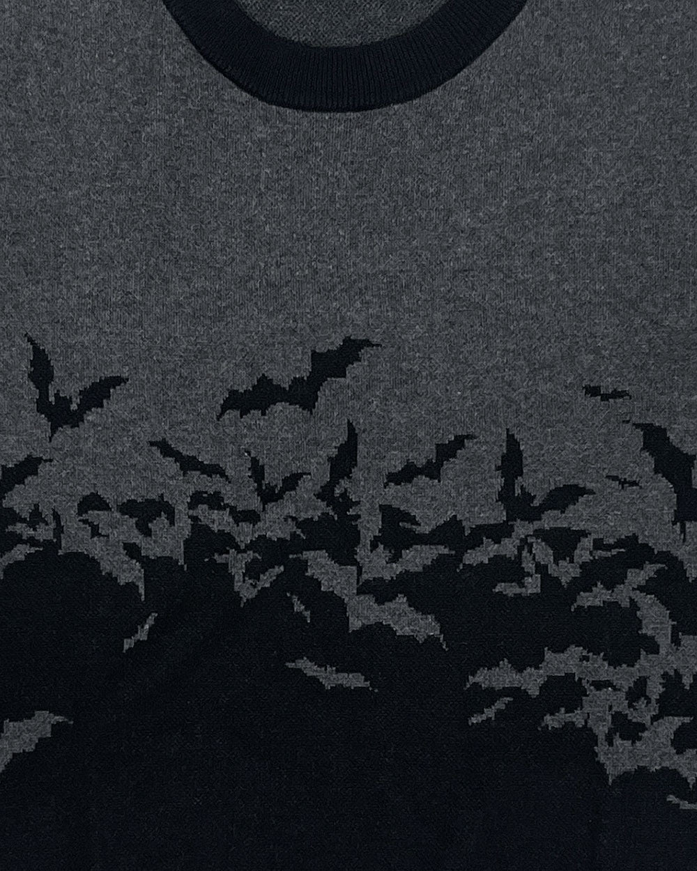 Crewneck knit sweater close-up of bat silhouette graphic on front