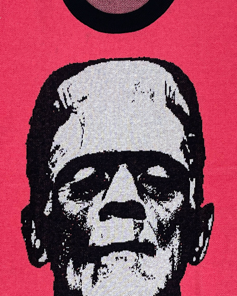 Close-up of pink sweater knit with black-and-white Frankenstein skull face graphic