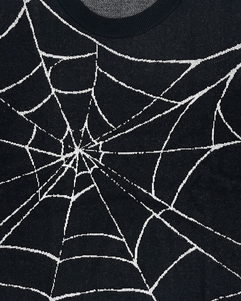 Black knit sweater detail with white web and starburst pattern