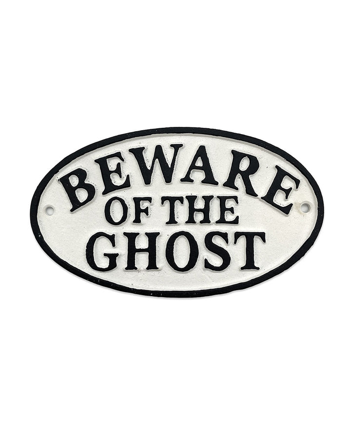 Oval decorative sign, white face with black border and bold “BEWARE OF THE GHOST” letters