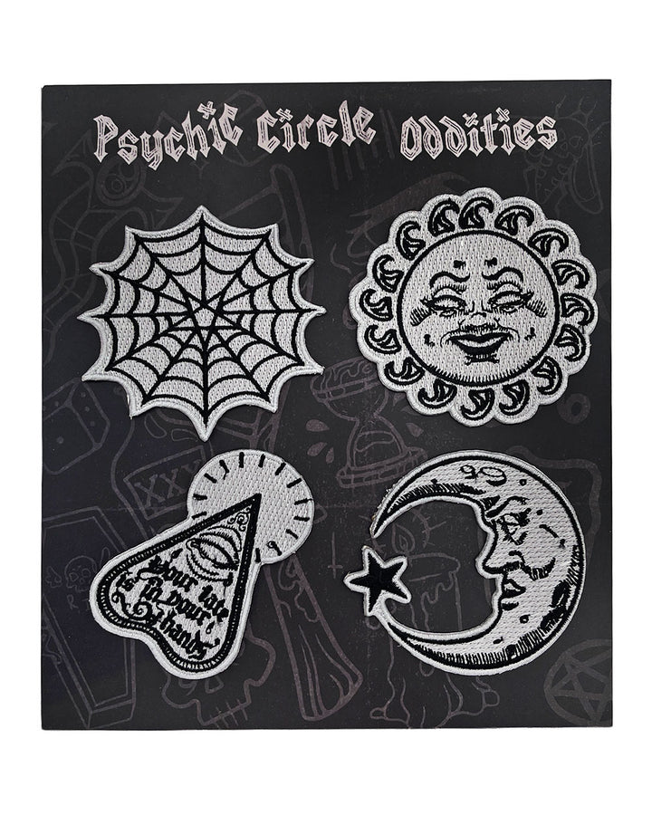 Four embroidered glow-in-the-dark patches arranged on a display card: sun, moon, web, and planchette.