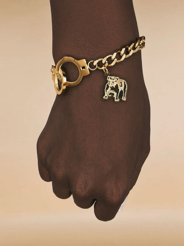 Gold chain handcuff bracelet on wrist with animal mascot charm