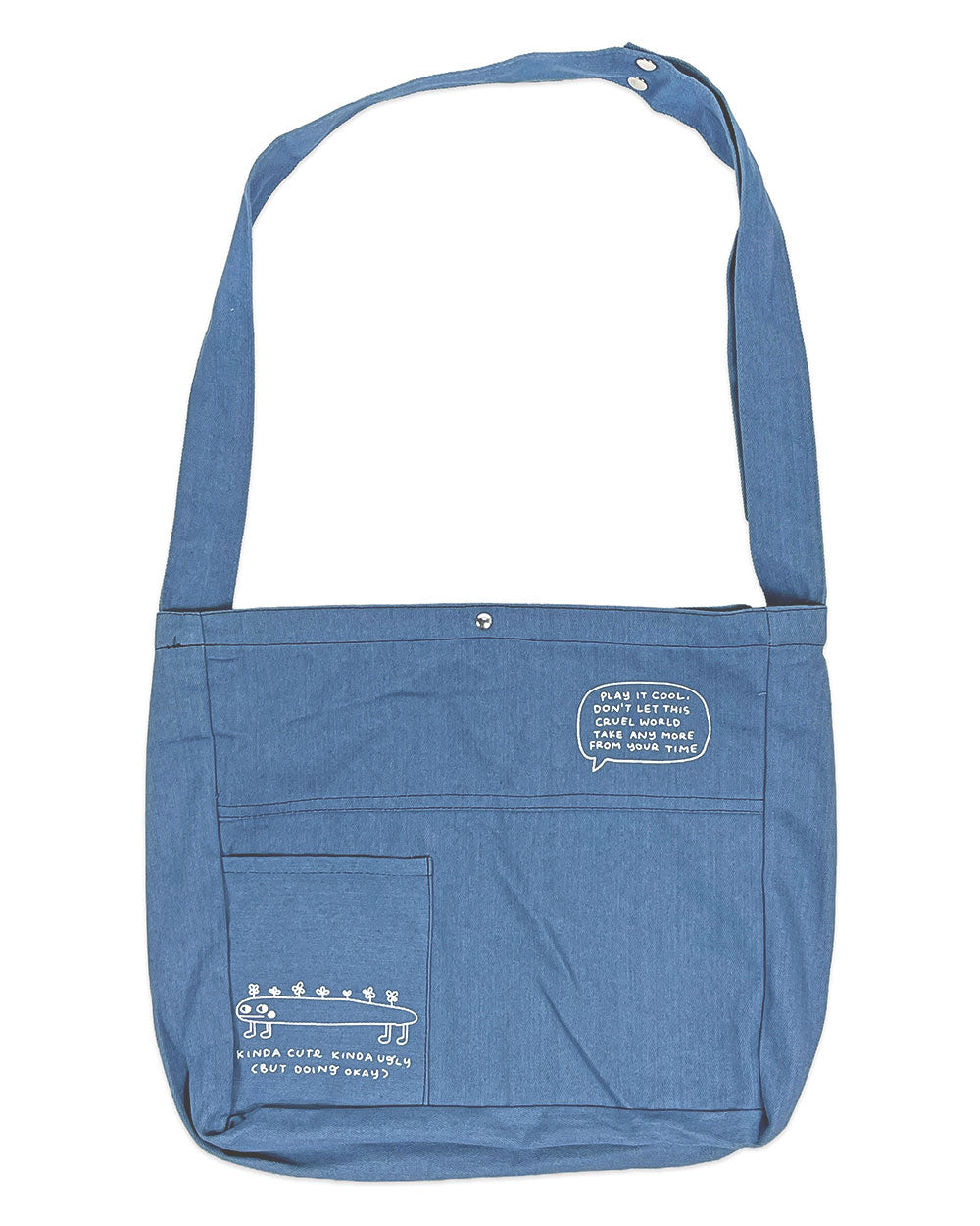 Blue denim tote bag with long handles, front pocket, and round metal snap