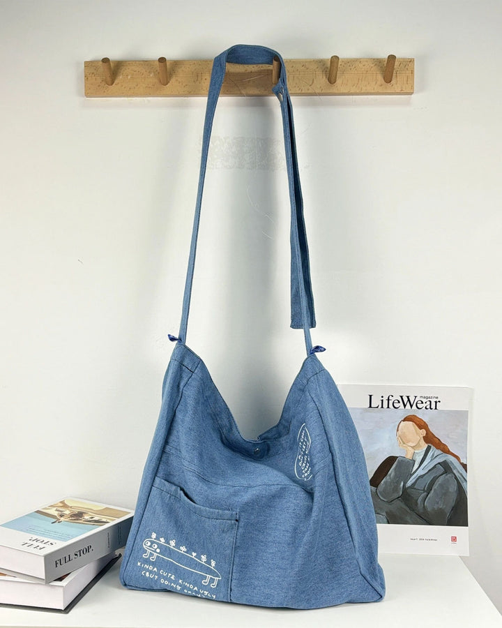 Blue denim tote bag with long shoulder straps and spacious open interior