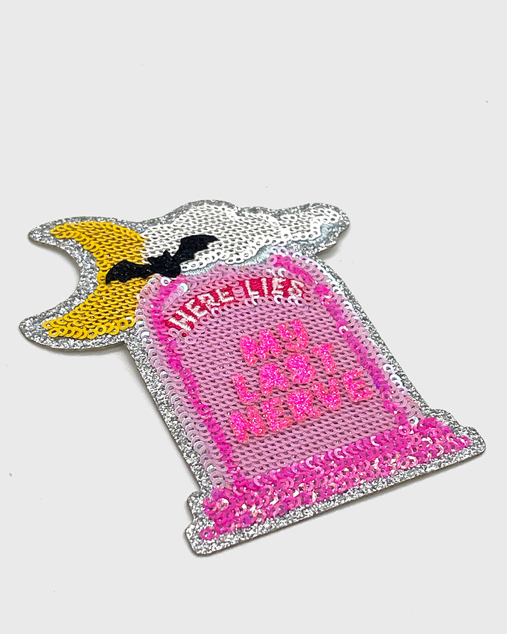 Pink and silver sequin patch tombstone with “HERE LIES” and “MY LAST NERVE”