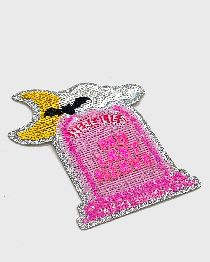 Pink and silver sequin patch tombstone with “HERE LIES” and “MY LAST NERVE”