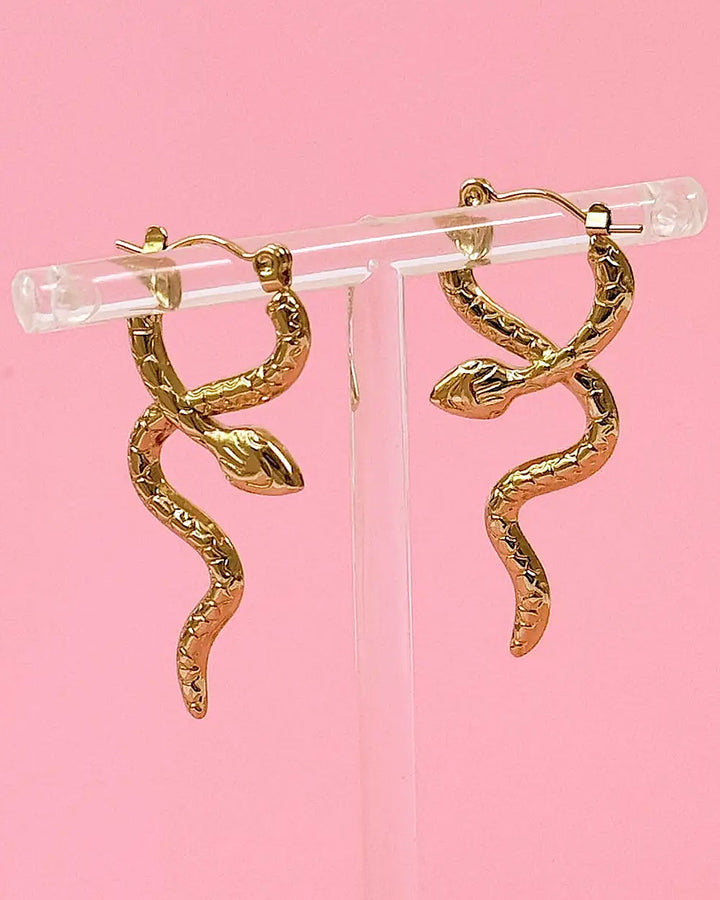 Gold serpent coil hoop earrings with snake-shaped drops and small leaf charms