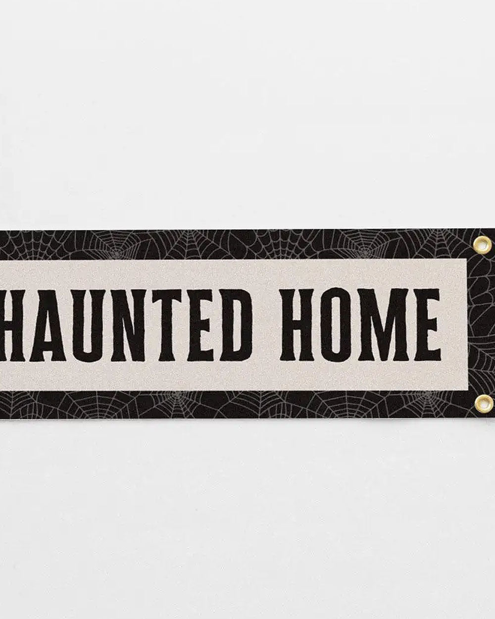 Felt Halloween banner close-up showing 'HAUNTED HOME' text and gold grommets.