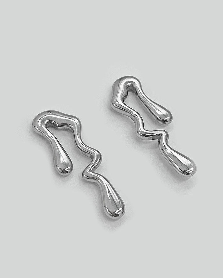 Pair of silver-tone abstract wavy drop earrings, one angled, polished finish