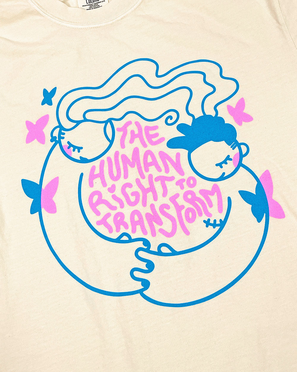 Cream unisex T-shirt close-up of blue and pink 'Human Right Transform' graphic